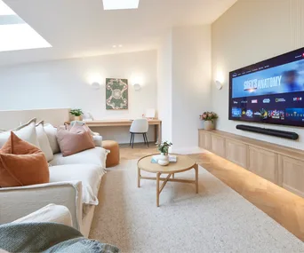 A neutral-toned lounge space with a desk and wall sconces