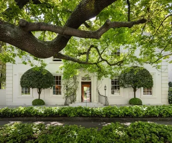 The stately white facade of the Myer family's Toorak manor, surrounded by leafy trees