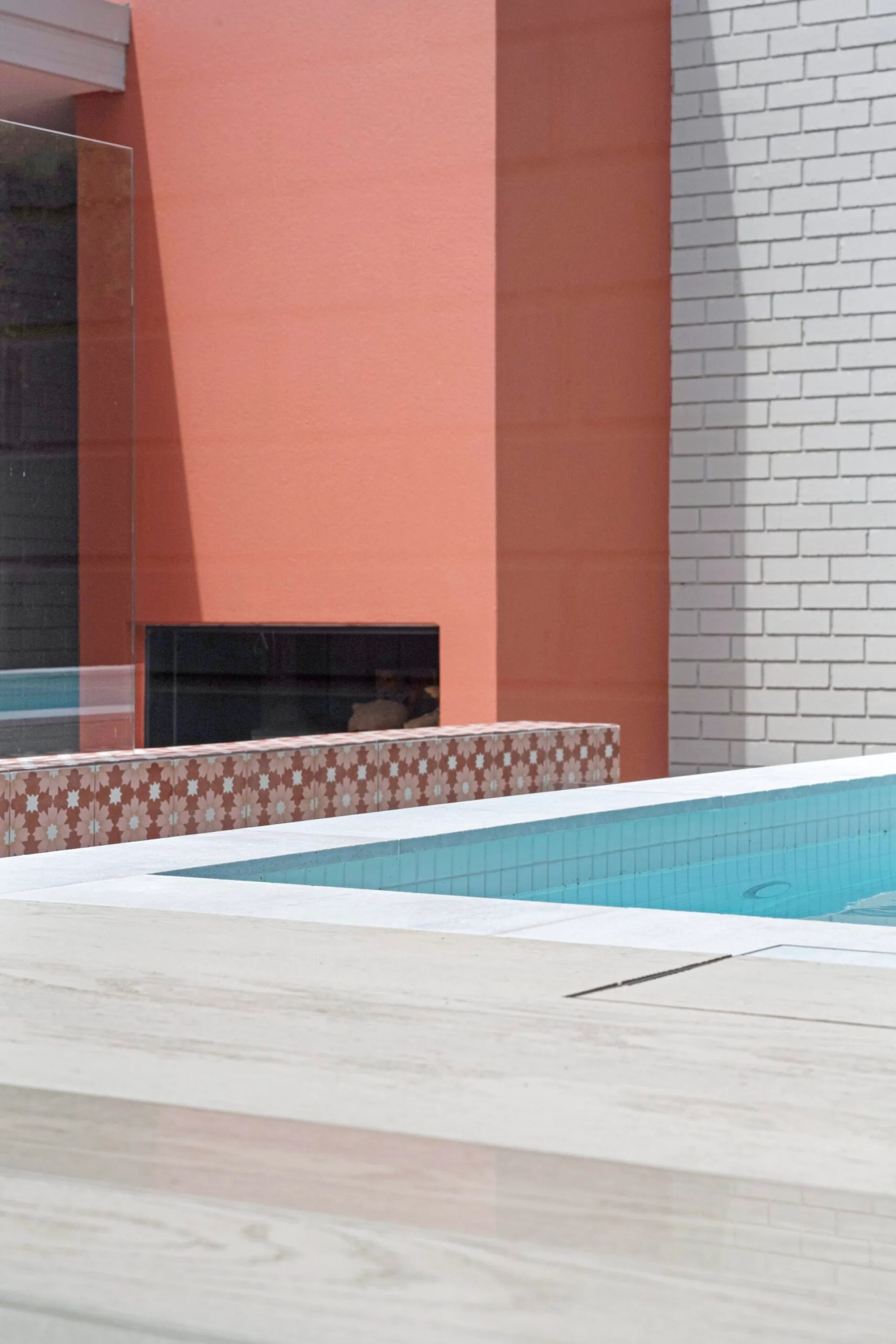 An outdoor area with a pink fireplace, Morroccan tiles and a pool