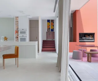 A spacious open-plan living and dining area with concrete floors and colourful accents