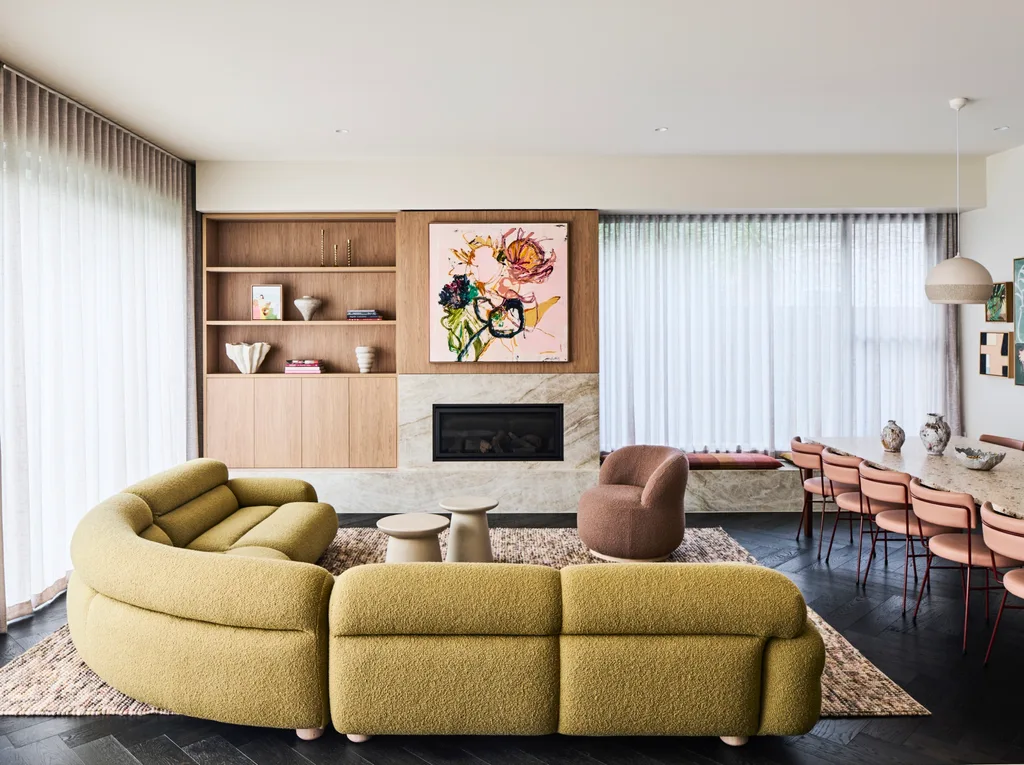 An open-plan living and dining area with a built-in fireplace and timber shelving