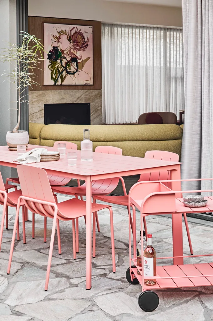An outdoor area with a bright pink dining set