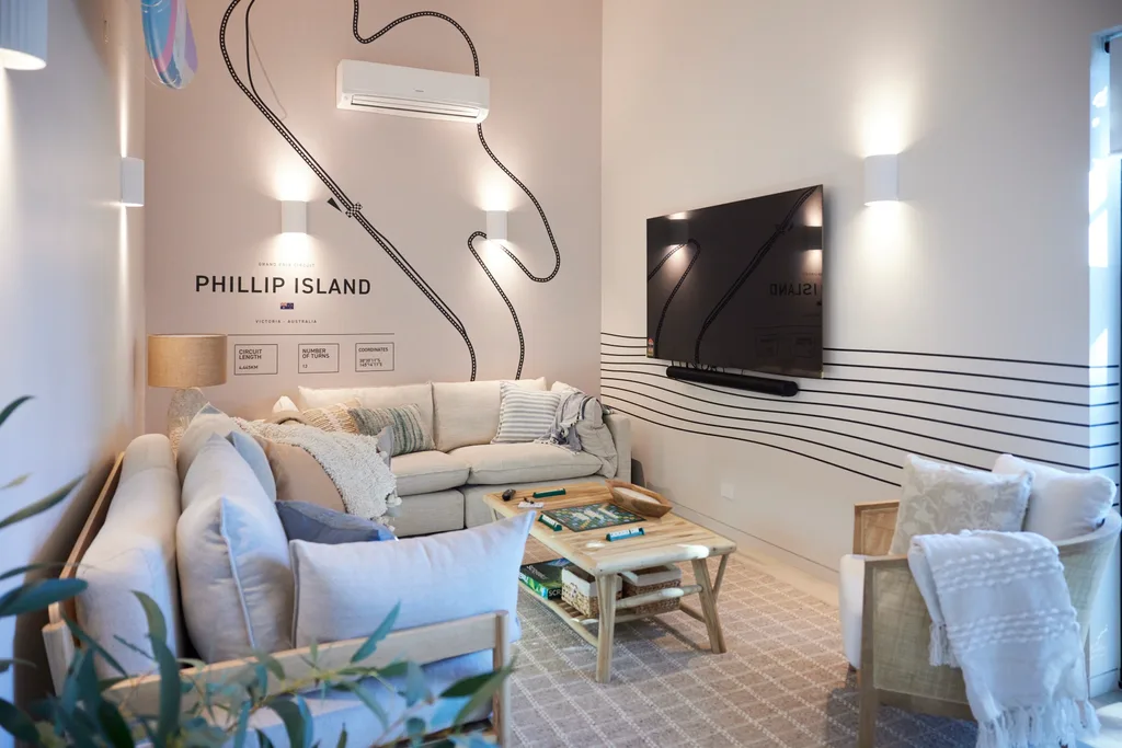 A lounge space with a Phillip Island wall decal, two neutral-toned lounges and a coffee table