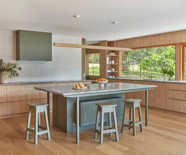 An open-plan kitchen with a green island bench