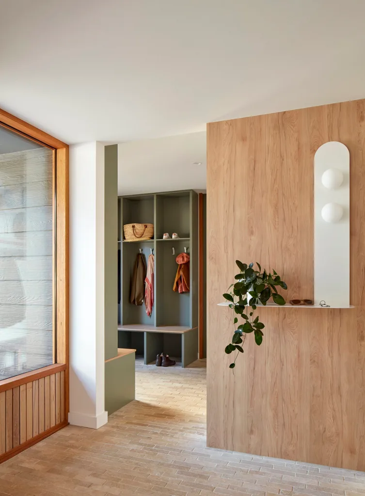 A mud room with green shelving