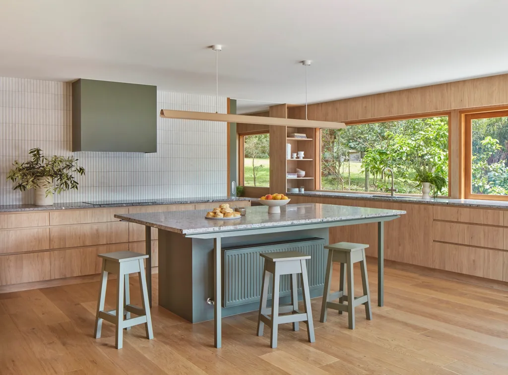 An open-plan kitchen with a green island bench