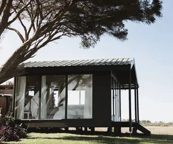 A modern shack beside a tree in Wallaga Lake