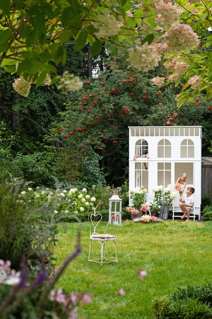 A garden with a white kids playhouse