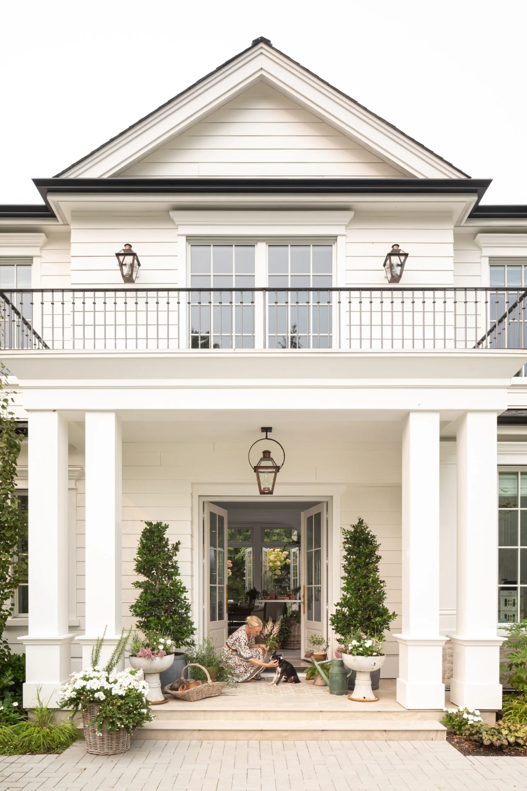 The fa&ccedil;ade of a large, white house with pillars and a balcony.
