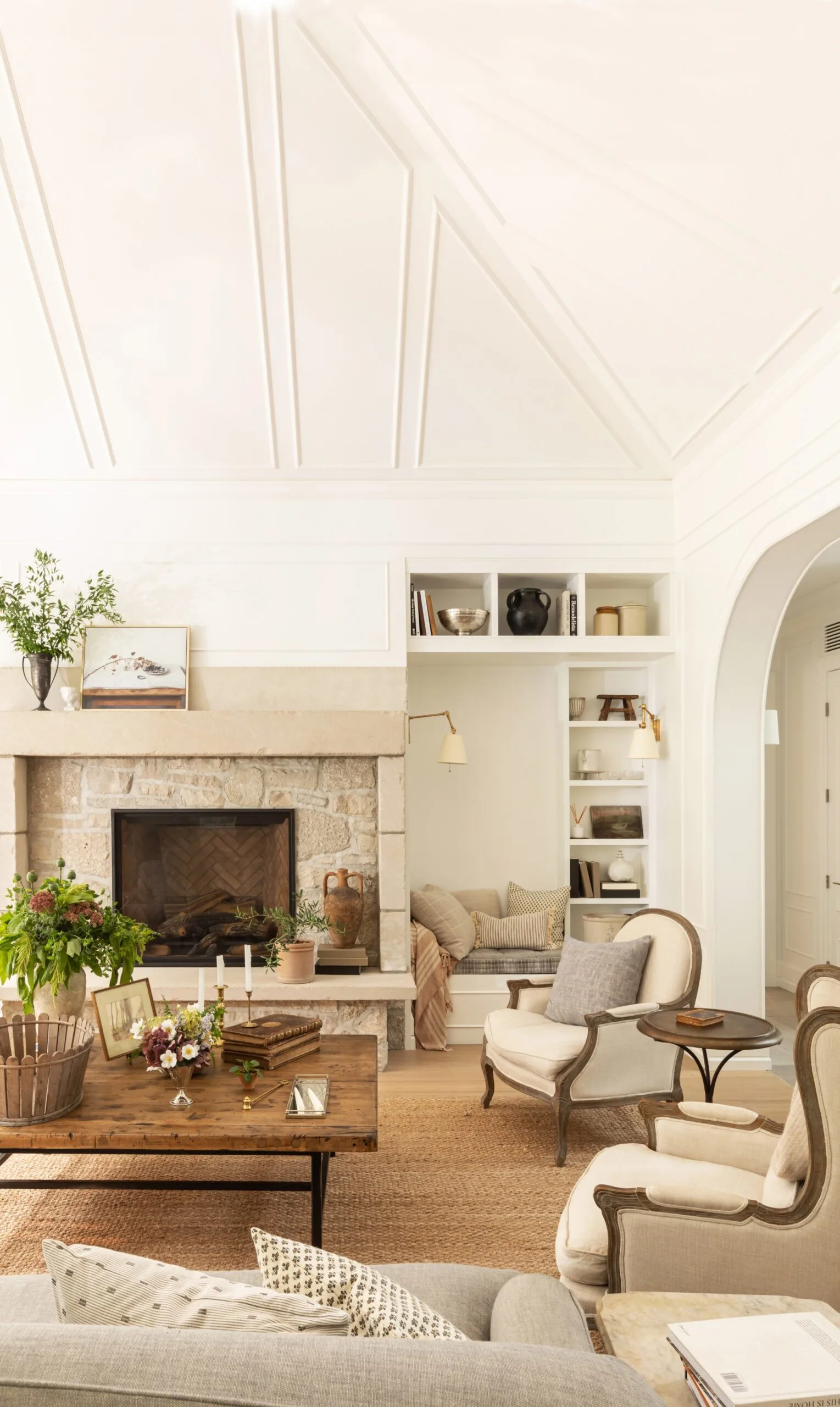 A living room with a pitched roof and classic neutral furniture
