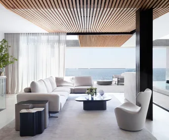 A monochromatic living room looking out onto the ocean