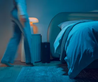 A person walking to their bed fitted with an Eight Sleep pod