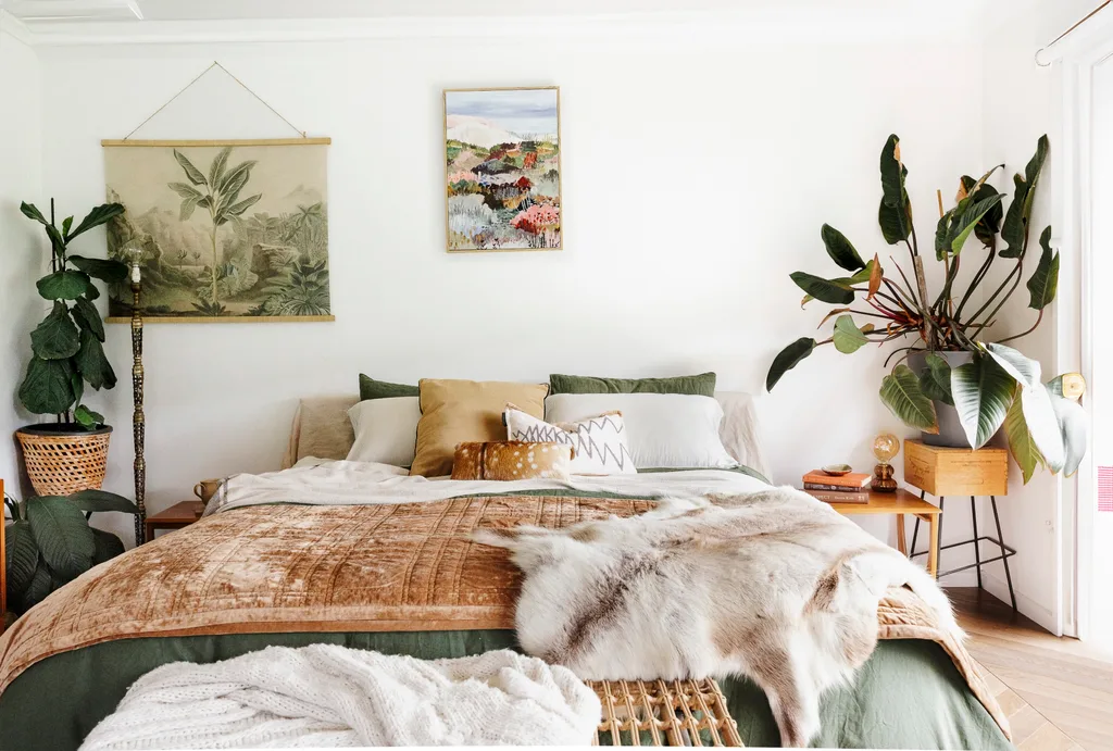 A white bedroom with plants and green bedding