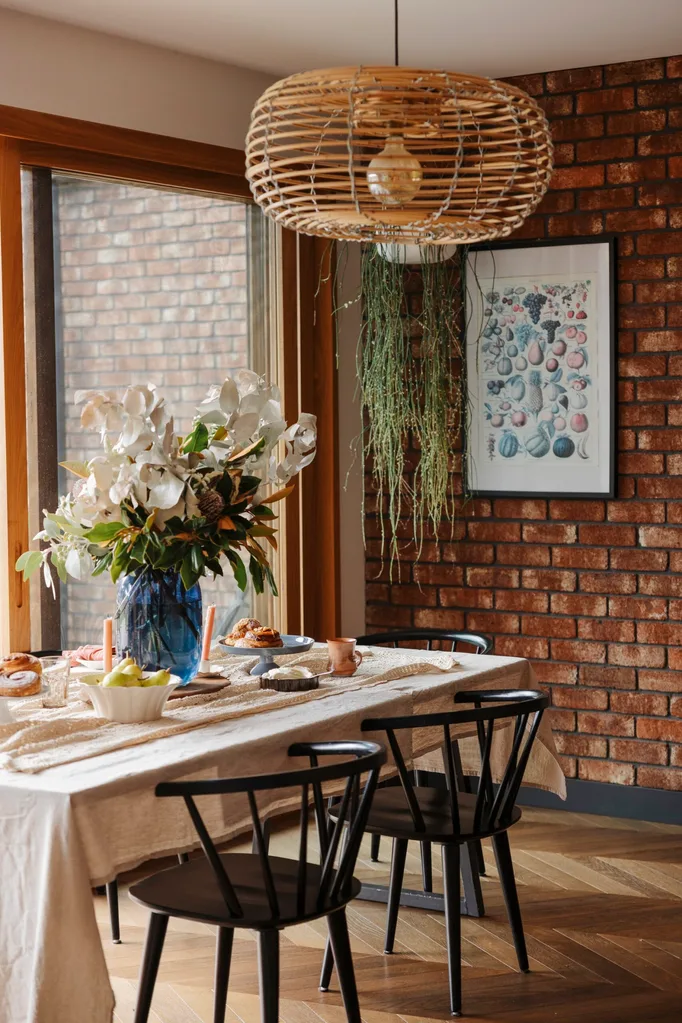 A dining room with a pendant light and exposed brick wall
