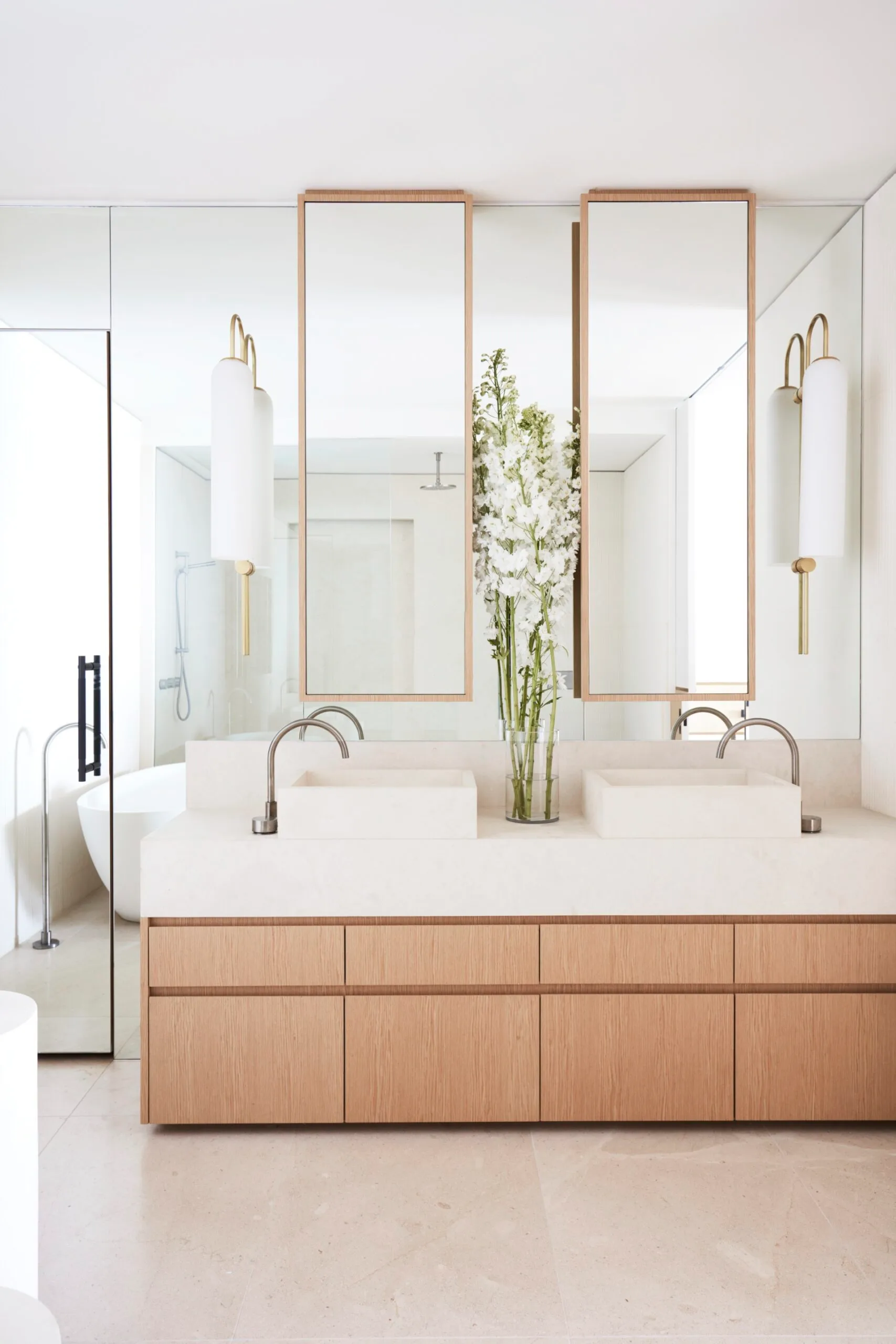A light and bright bathroom with a double sink and timber cabinetry