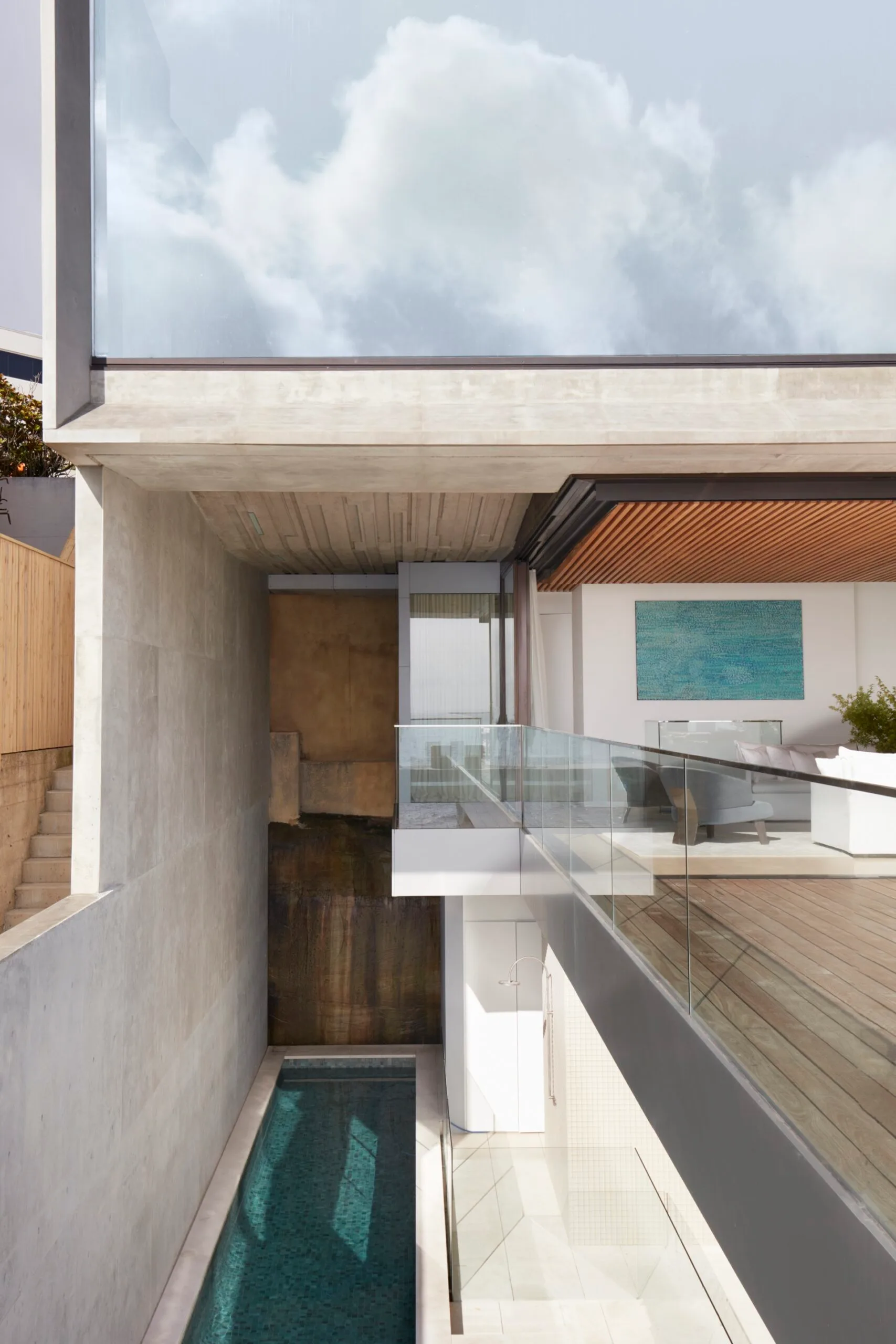 A modernist concrete and timber home with a lap pool