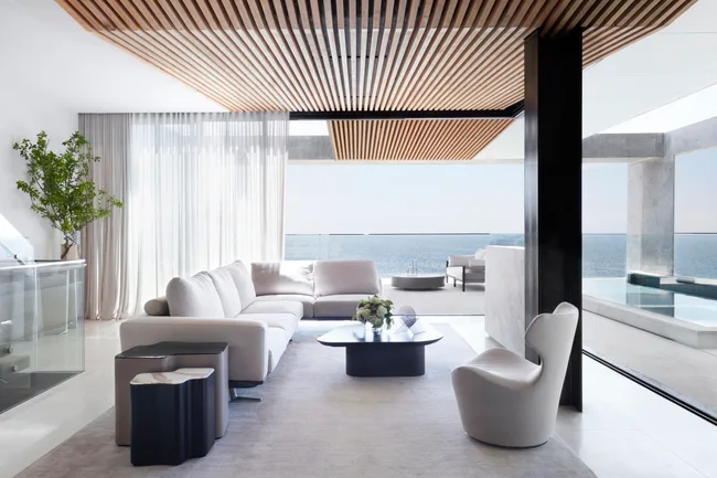 A monochromatic living room looking out onto the ocean
