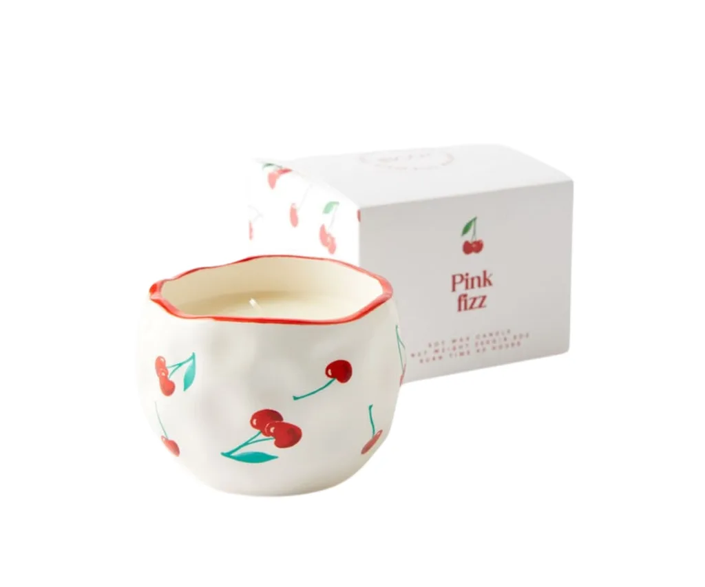 A candle with a cherry painted holder