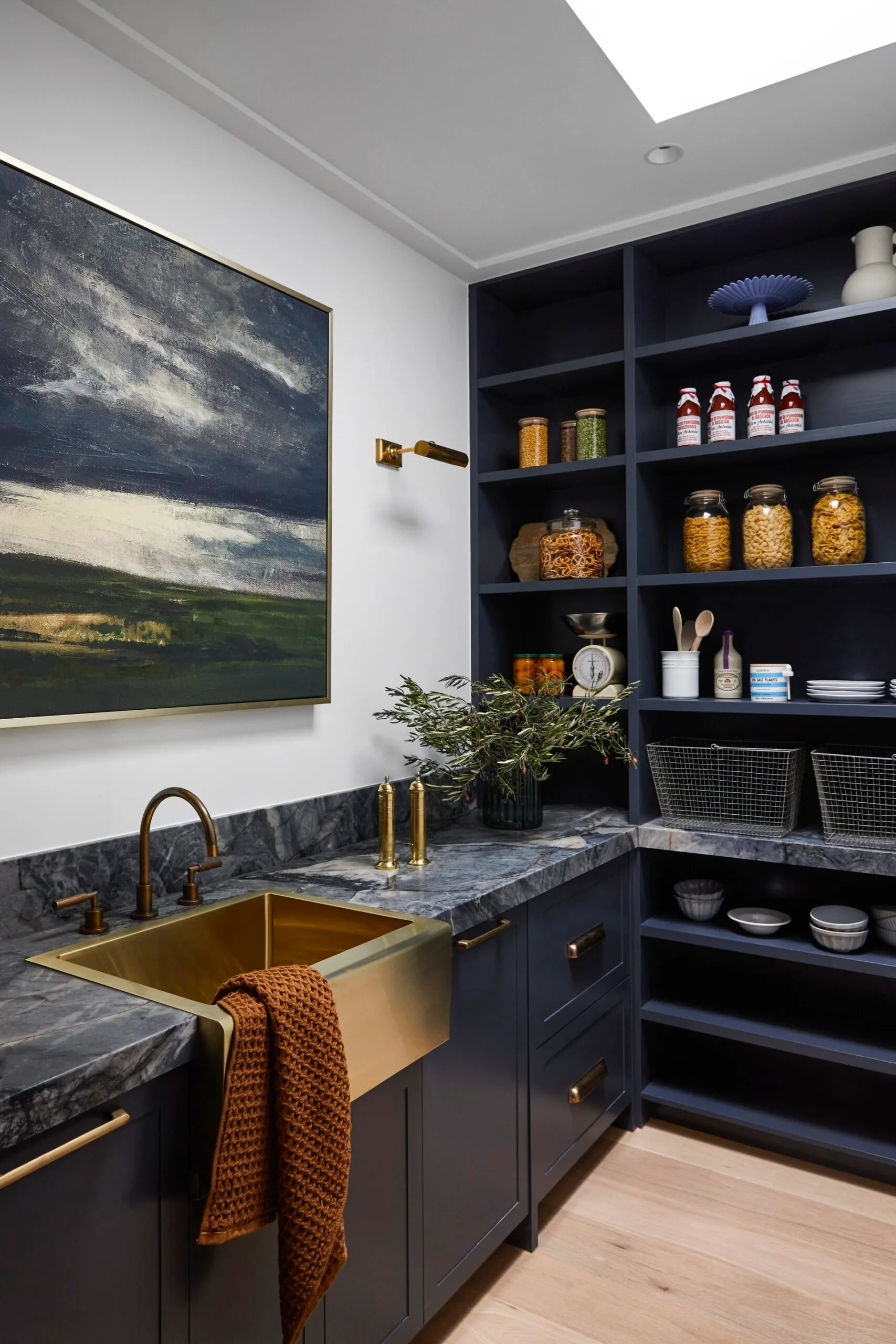 A butler's pantry with blue finishes and a gold sink