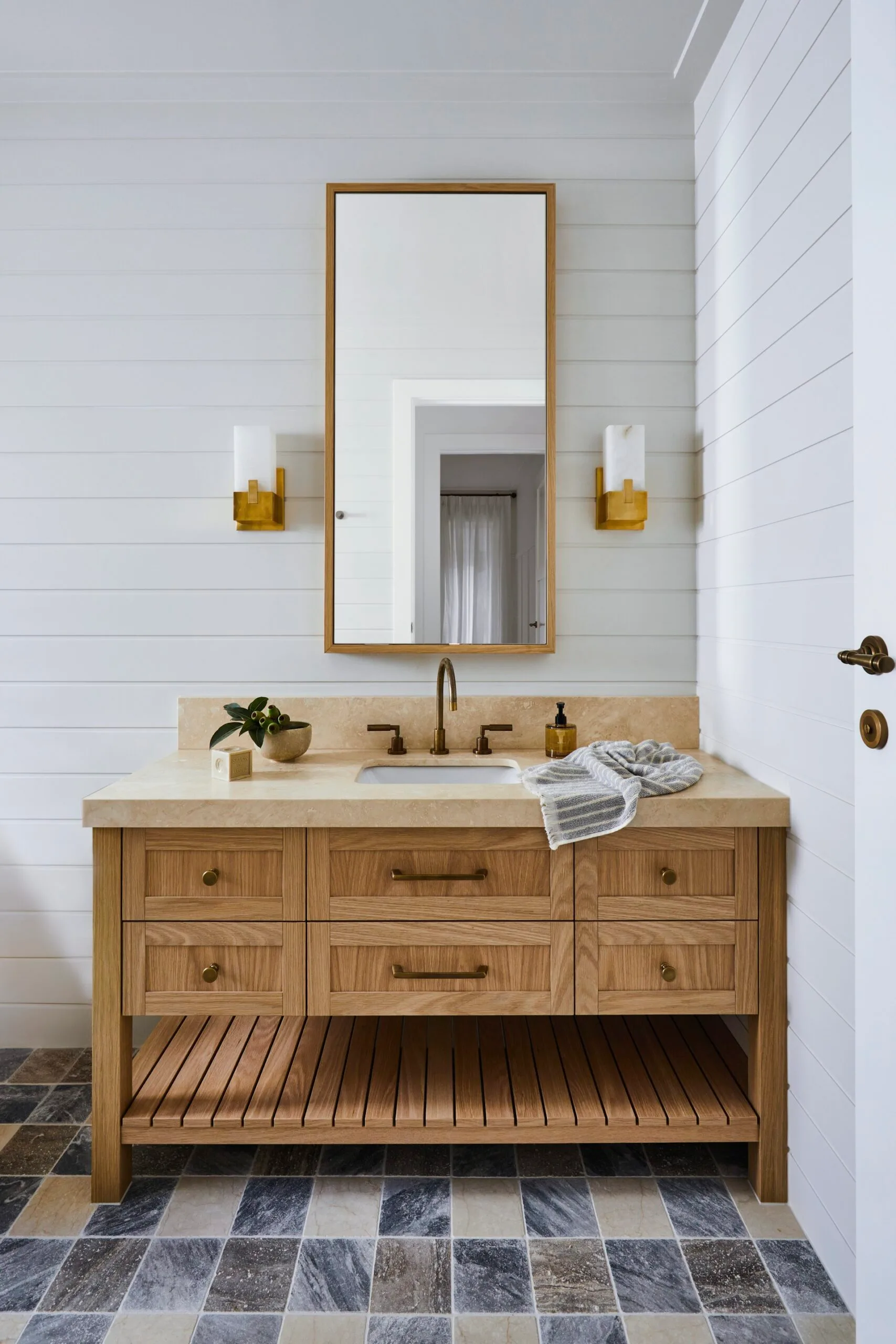 A bathroom with weatherboard walls and a timber vanity