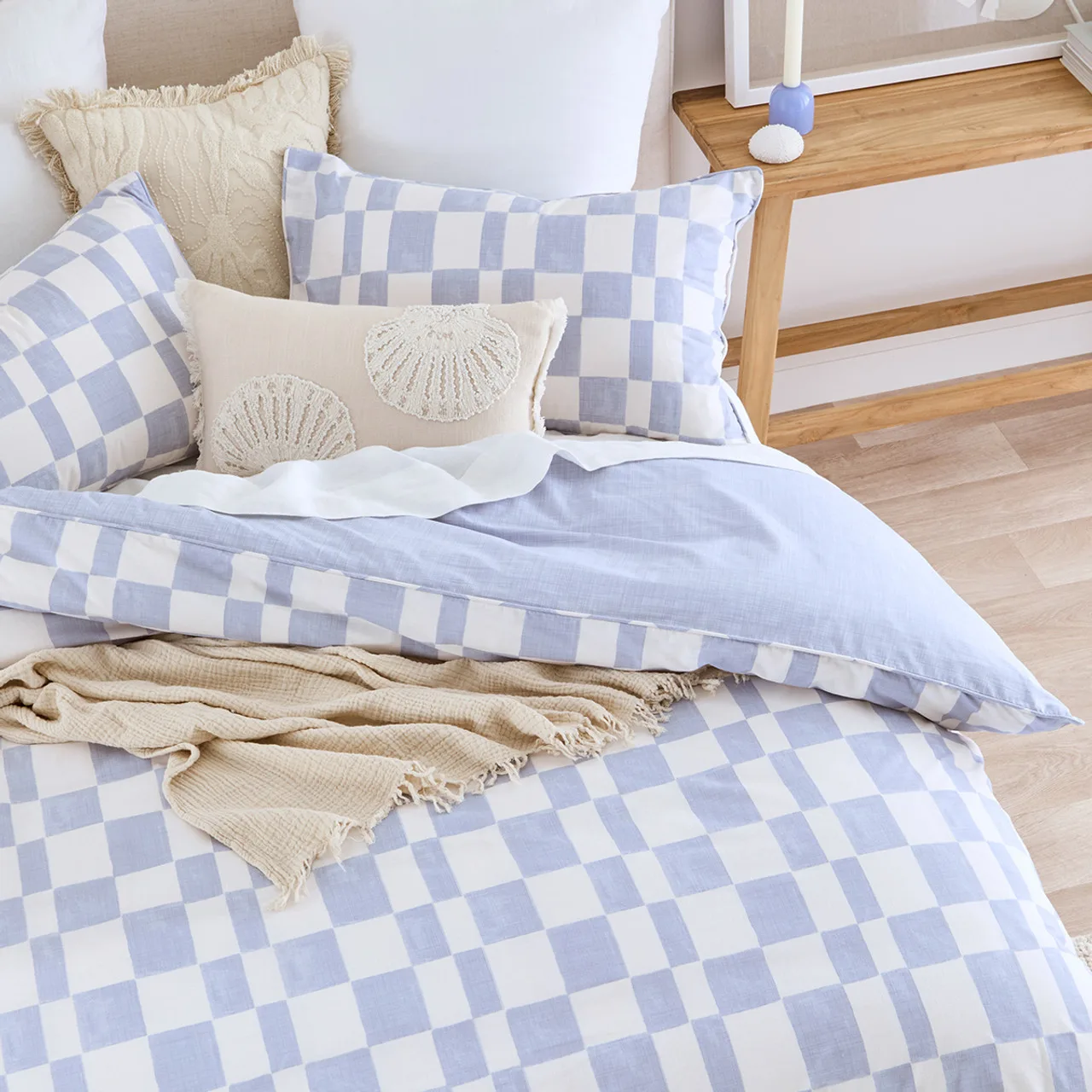 A bed with a blue and white check print duvet from Pillow Talk