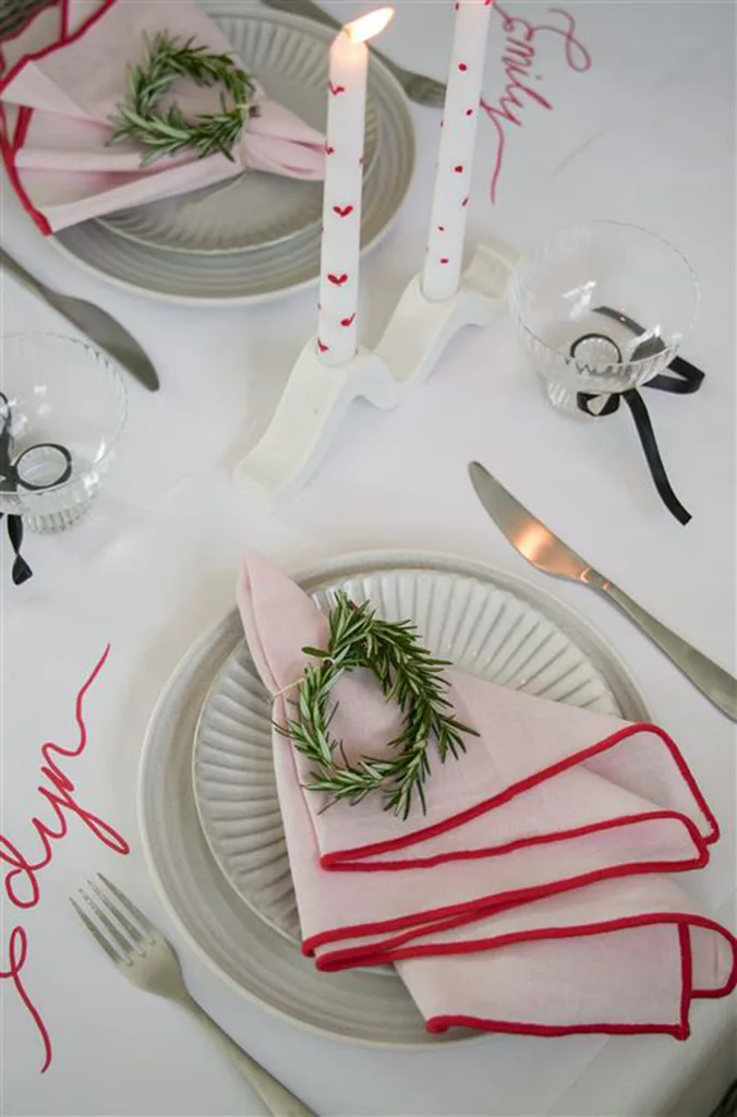 christmas table with pink and red napkins and pillar candles