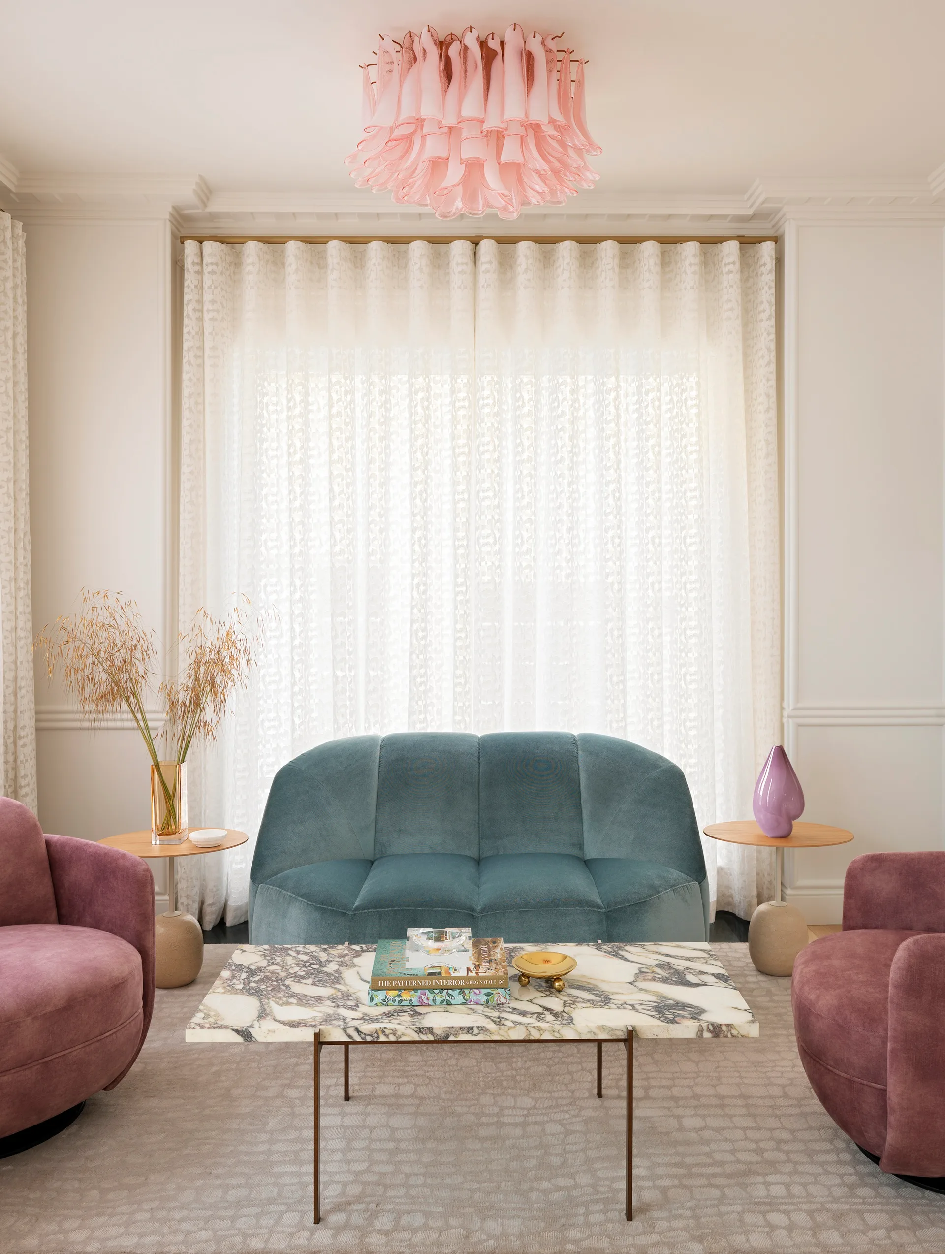 A contemporary sitting room with pastel accents and velvet lounges
