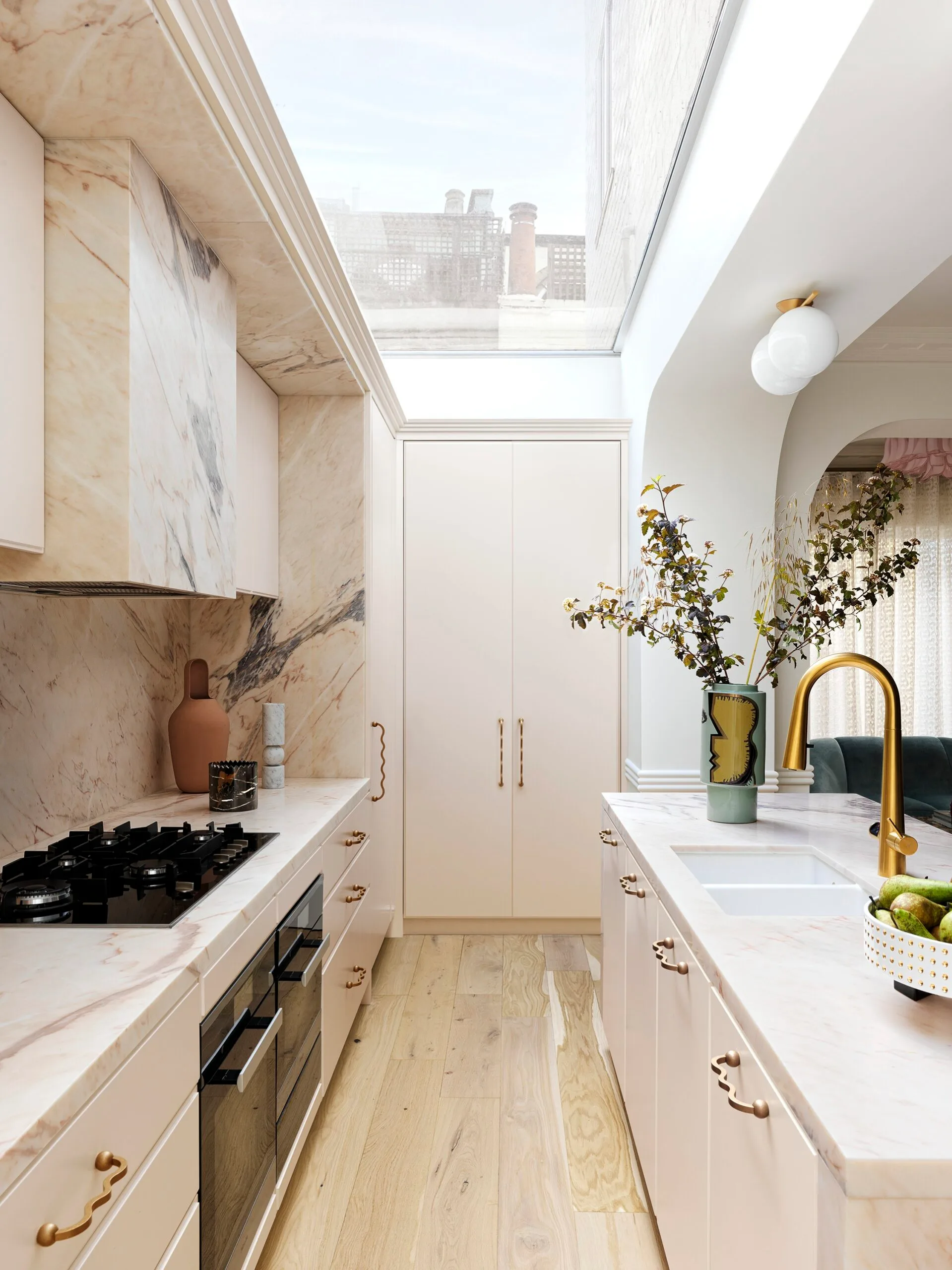 A contemporary kitchen with a skylight and marble finishes