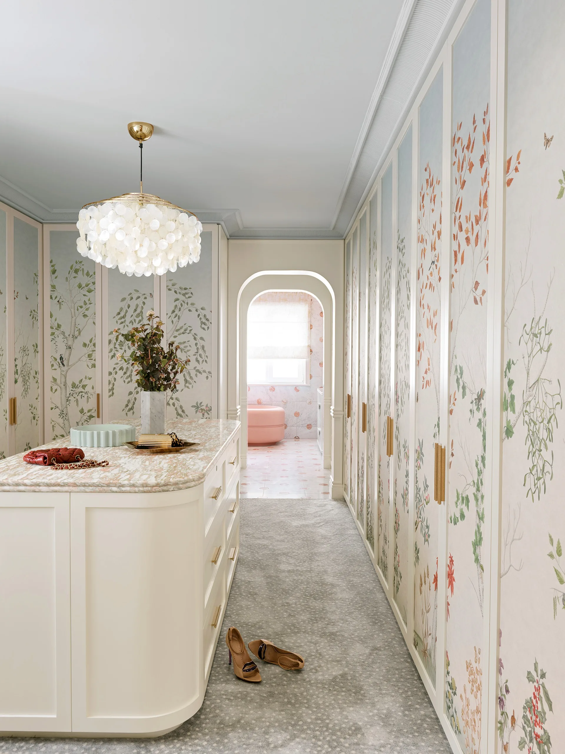 A large walk-in wardrobe with statement botanical wallpaper