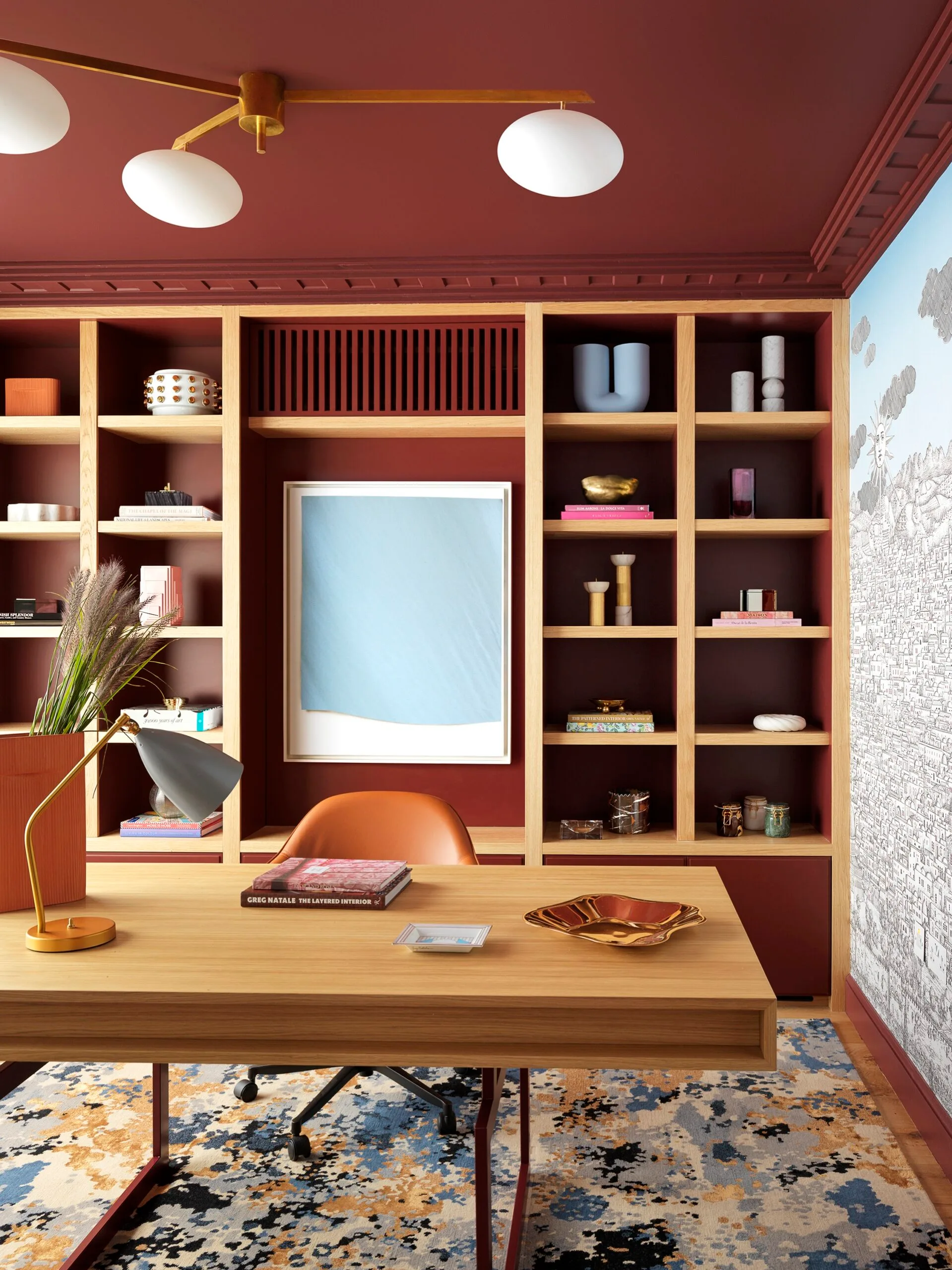A contemporary home office with a wall of shelving and timber desk
