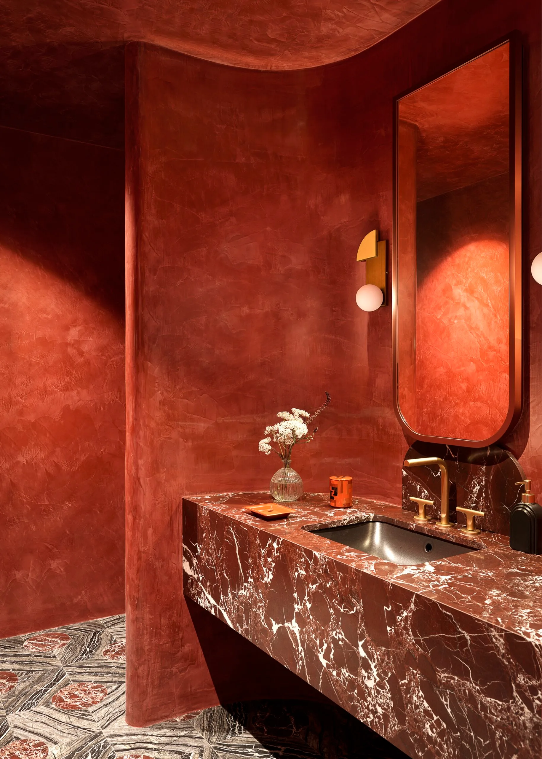 A red and marble bathroom with curved walls