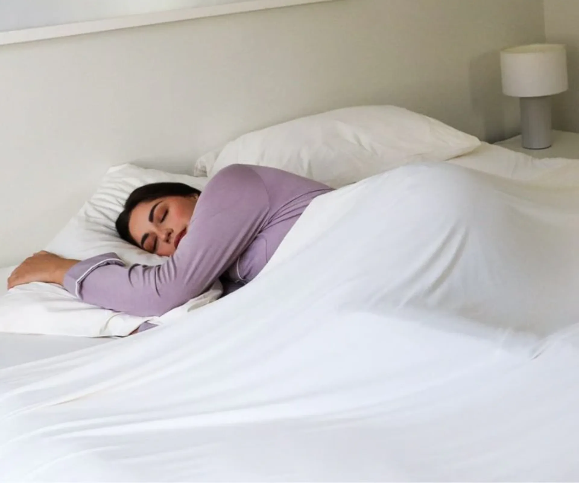 A person sleeping beneath a Morgan and Reid Cooling Sheet