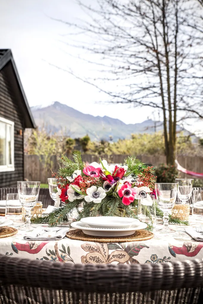 An outdoor table with a mountain in the background, decorated for Christmas lunch