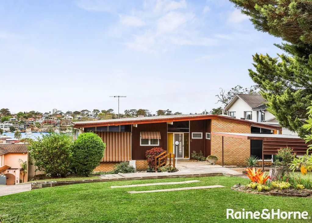 A mid-century style home with striped awnings and a pitched roof