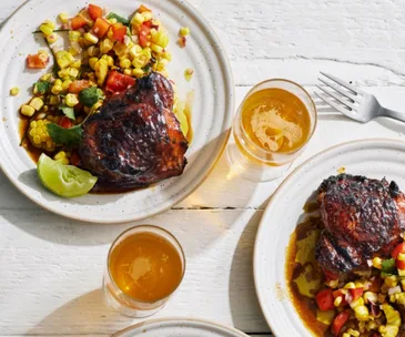 A plate of jerk chicken with a corn salad