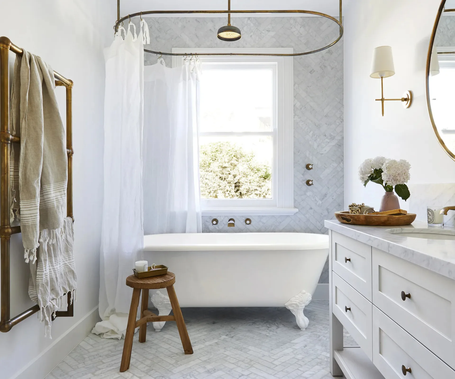 A classic bathroom with a clawfoot tub, rain showerhead and timber stool