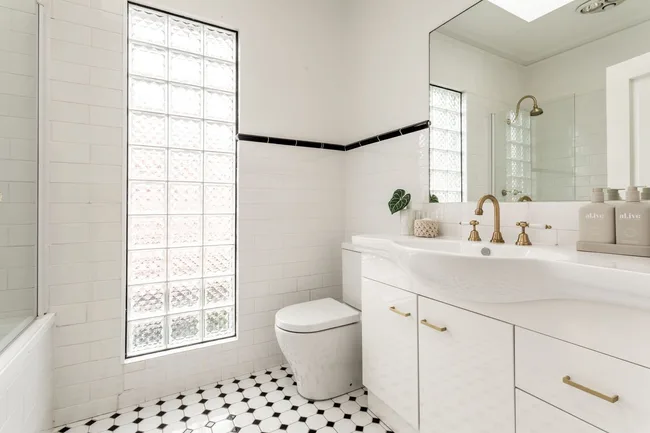 An art deco-style bathroom with a glass brick feature