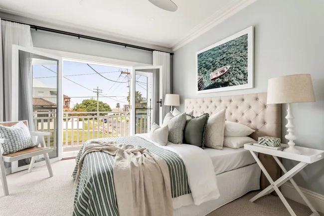 A neutral-toned main bedroom with green accents