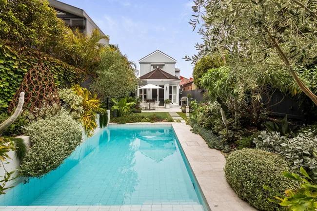 A swimming pool surrounded by lush gardens