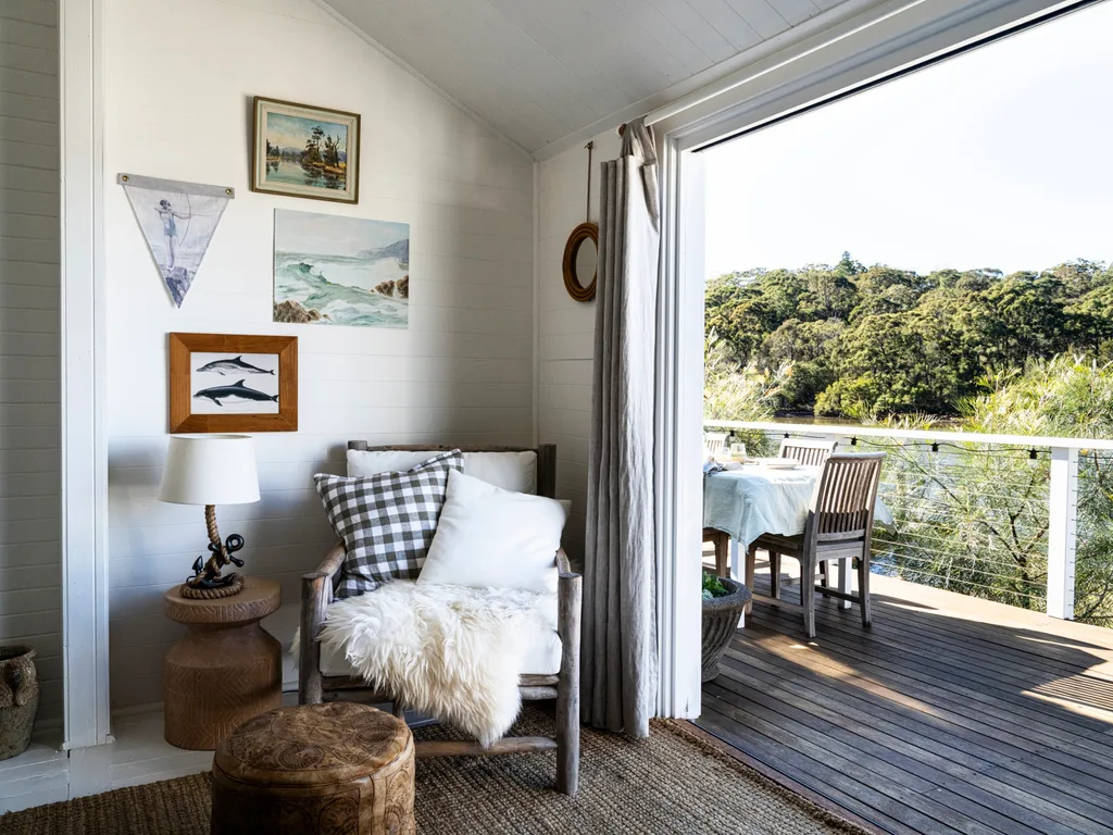 The view from a lounge area onto a large deck which overlooks the Hawksbury River.