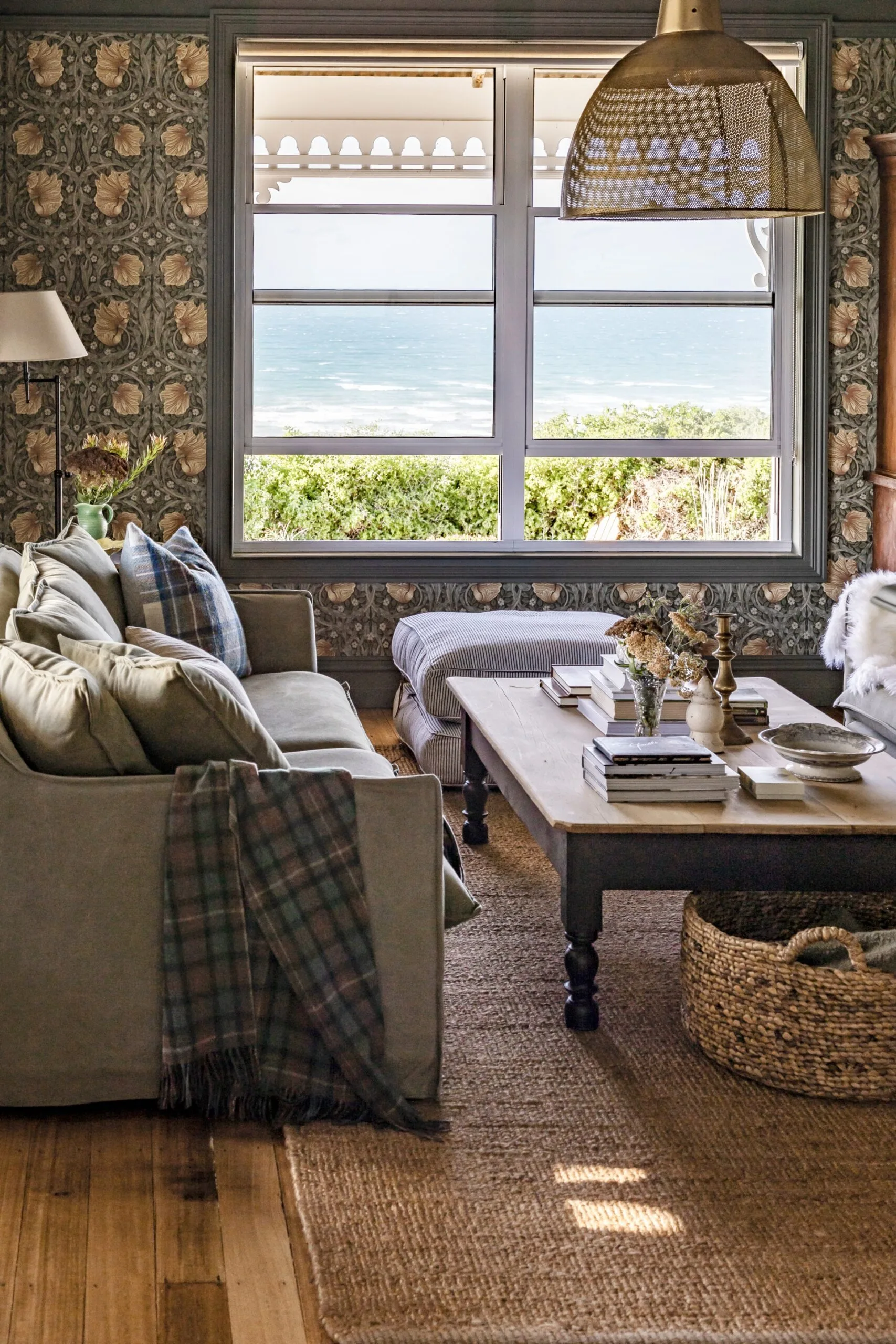 A cosy living room with dark green patterned wallpaper and an amazing view