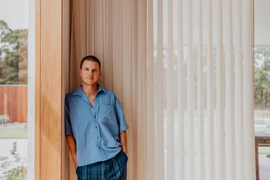 Cricketer Adam Zampa at home in front of sheer white curtains