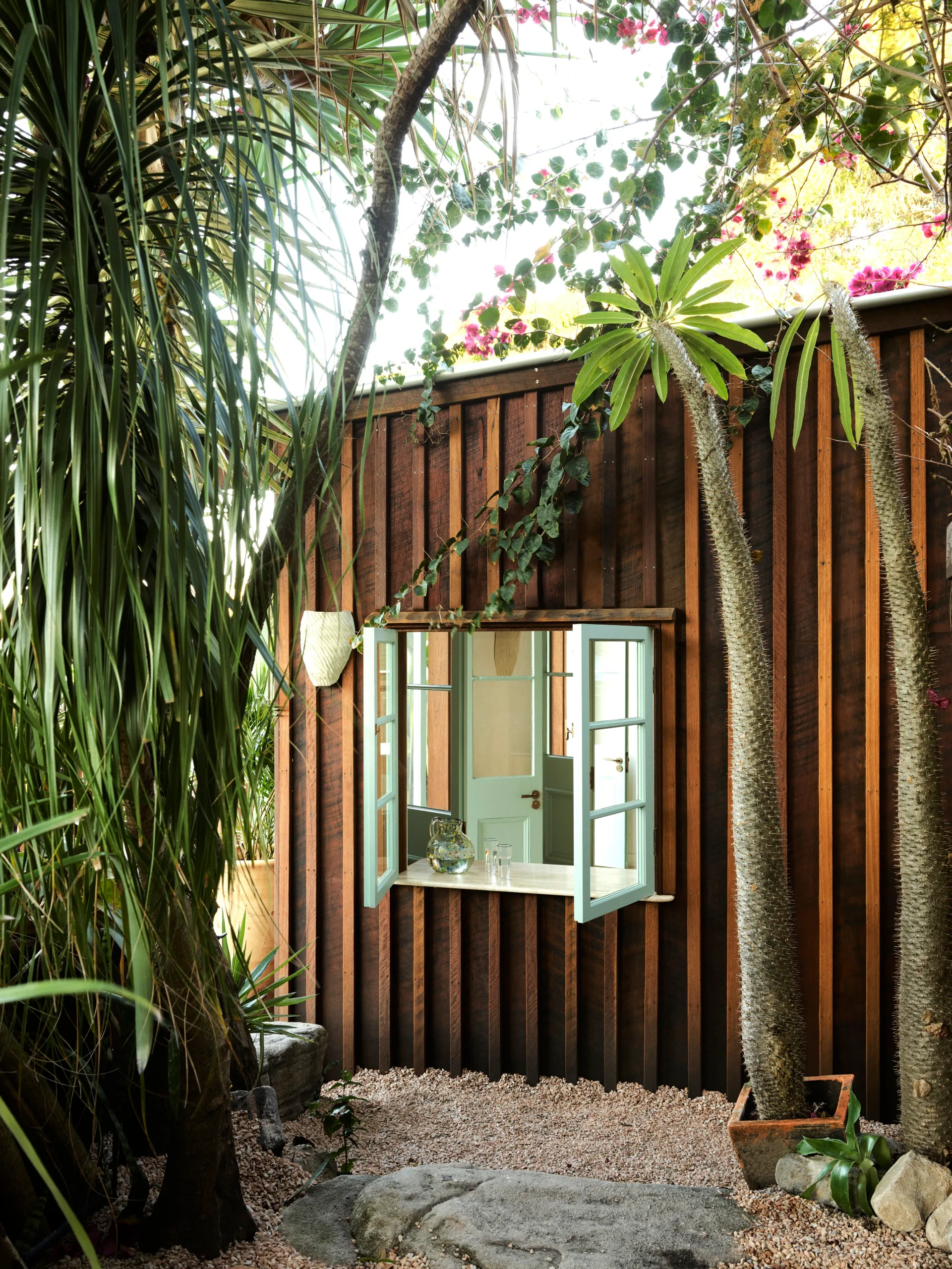A weatherboard home with a blue framed window