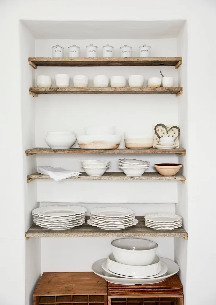 Open shelving features white kitchen and serving ware