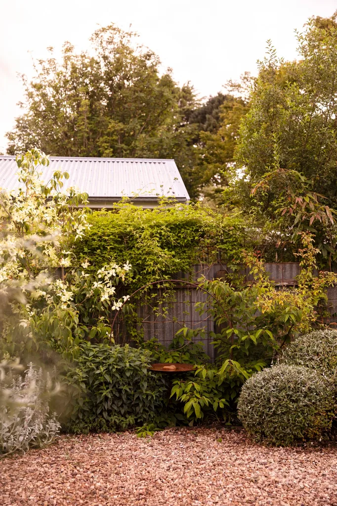 The corner of a garden designed by Tim Pilgrim with a small copper coloured bird bath