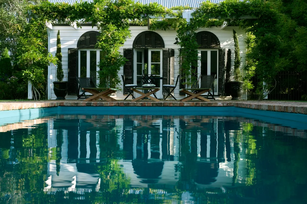 A swimming pool in a brick paved home outdoor area owned by Collette Dinnigan