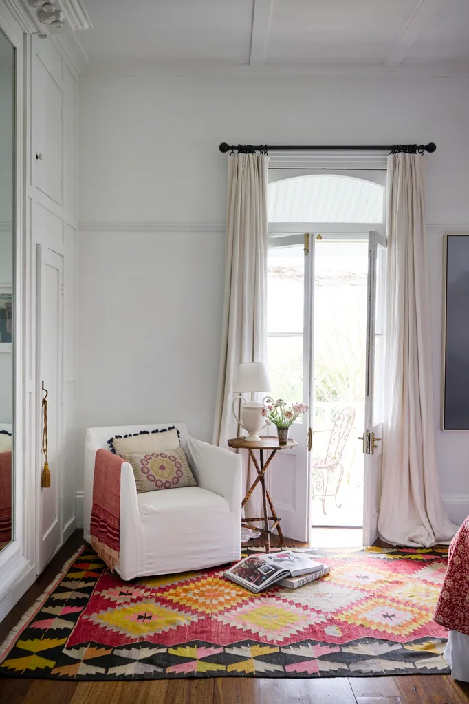 A colourful rug and white armchair in a living space