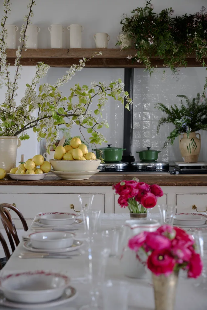 Collette Dinnigan adorned her home dining tabled with flowers beside a kitchen bench with bowls of lemons