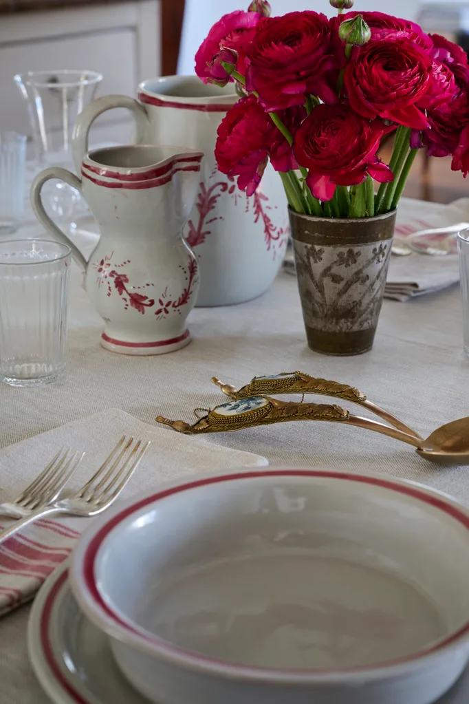 A close up of a dining table dressed with roses and white and pink dinnerware
