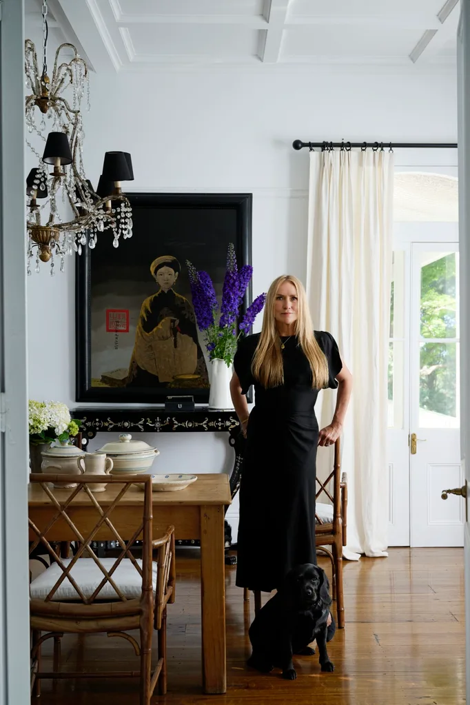 Collette Dinnigan in her Southern Highlands home, stood in a dining room beside her dog